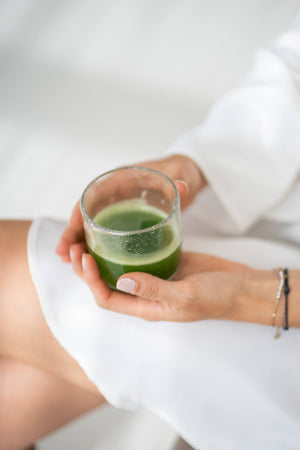 vrouw zit en houdt matcha thee vast