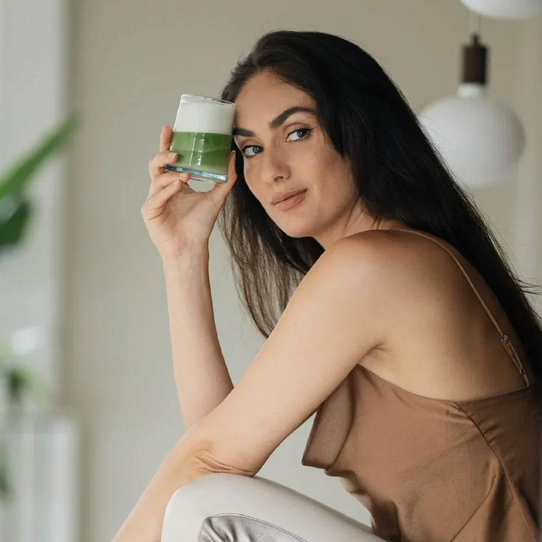 vrouw poseert zittend met een matcha latte